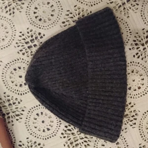  - Ribbstickad Mörkgrå ullmössa.

100 % Lammull
