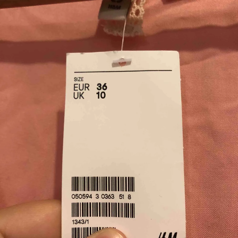 Somrig rosa jumpsuit med spetsdetaljer från H&M. Storlek 36/S, aldrig använd med prislapp kvar, nypris 299 kr. Perfekt för semester! . Klänningar.