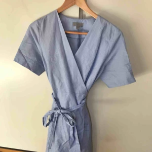  - Omlottklänning i ljusblått från COS