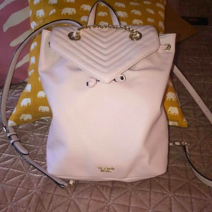  - Ryggsäck från Victoria’s secret. Köpt på Malaga flygplats augusti 2018. Som ny. Näst intill oanvänd. Ljusrosa. Ca 30 cm hög. Köparen betalar frakt. 