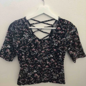  - Blommig T-shirt från bershka. Snörningen är på ryggen. Frakt 36kr 