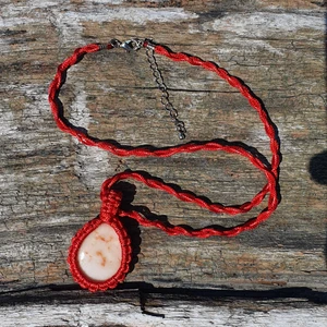 Macrame halsband - Handgjort Rött macrame halsband av syntetisk tråd. Stenen är slipad och lackad på ena sidan. Den har ett nickelfritt silvrigt lås. 