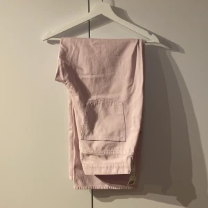 Ljuslila/rosa jeans  - Ljuslila/rosa jeans från H&M med wide leg fit. Helt oanvända med lappen kvar. Storlek 42/L. Nypris 399kr, mitt pris 150kr. Säljes pga fel storlek. Köparen står för frakten! 