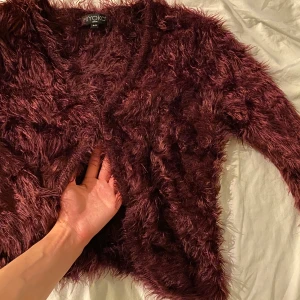 Fluffig vinröd kofta - Höstig vinröd kofta, i fluffigt material. Passar en XS och S mer än en M. Jättemysig! Endast använd 2 gånger sedan tvättad! Frakt tillkommer!