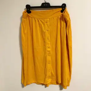 Senapsgul oanvänd kjol i mjukt material. Storlek XL men passar även en storlek L. Köpt för 349 kr.