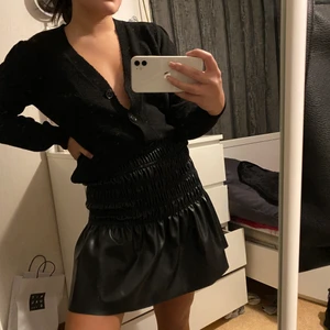 Svart kofta & skinnkjol - Svart snygg kofta med lite puffigare axel. Så snygg att bära båda uppvikt & nedsläppt! Skinnkjol som är väldigt festlig & använd endast 1 gång tidigare, båda i storlek S & väldigt bra skick! 150kr/st