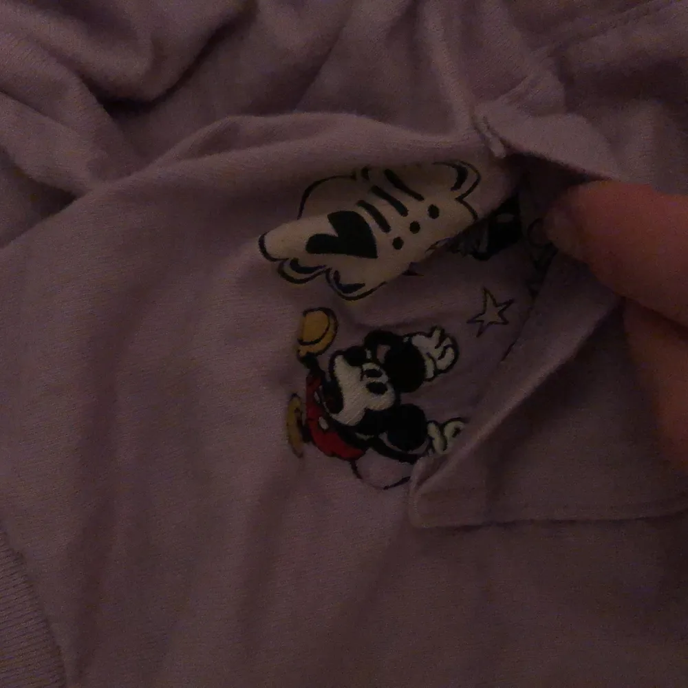 Lila T-shirt med mickey mouse innanför fickan. T-shirts.