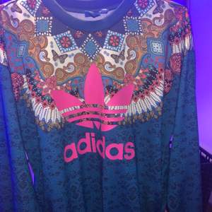 Adidas sweatshirt med rosa adidas tryck därframme, själva tröjan är blå med massa trevliga mönster! Bla fjärilar och blommar!   Pris: 300kr 