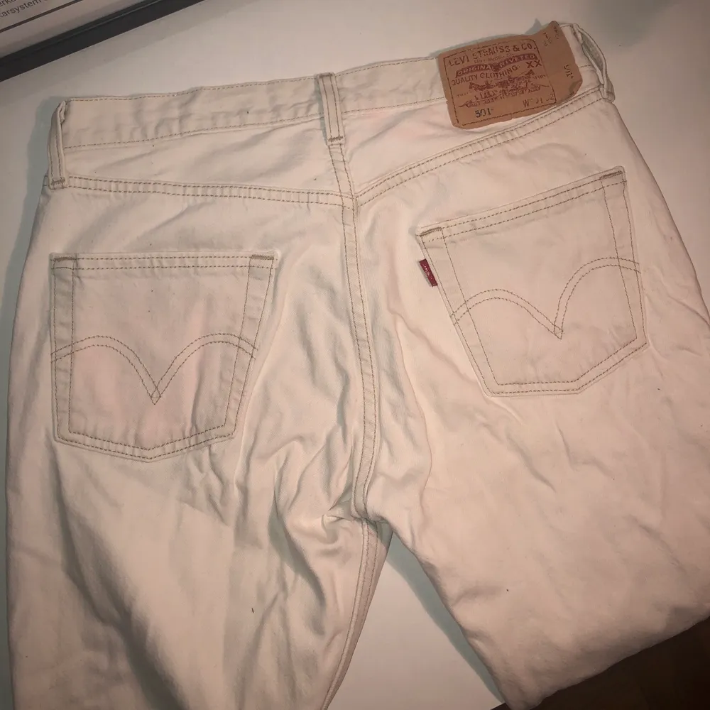 Vita Levis jeans, köpta på secondhand i Barcelona. De är uppvikta/sydda. Är i bra skick men med en ljusrosa fläck på ena backfickan och linningen, vilket syns på första bilden. fläcken är dock inte framträdande. Storlek är W 30 L 32 men som sagt uppvikta. SF 501. Jeans & Byxor.