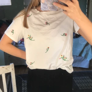 Blommig t- shirt 💐🌷🌸🌺 - Jättefin vit t-shirt med sydda små blommor på🌸🌸använd ett fåtal ggr så i ett mkt bra skick🥰
