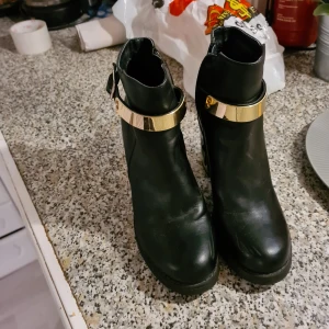 Högklackade boots  - Ett par högklackade boots från din sko i stl 38. Med guldmedaljer 