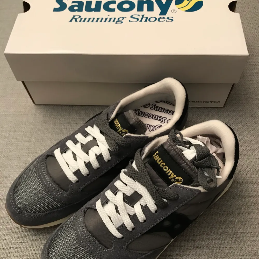 Helt oanvända supersköna Saucony sneakers i originalförpackning. Storlek 39, 24.5cm. Gråa med svarta detaljer. Kan skickas. Köparen står för frakt. (+63kr) med postnord spårbart. Skor.