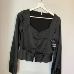 Festtop - Snygg top från Nelly storlek 34 aldrig använd !  Funkar att ha som ”kofta/jacka” över en top eller som den är då det går att justera med knapparna