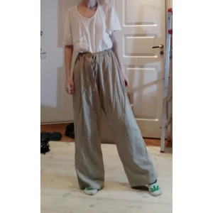 Rutiga byxor - Beiga rutiga vida byxor. Det står storlek XL på etiketten, men eftersom de har dragsko så kan man anpassa midjan. De är rätt långa. (Jag på bilden har vanligtvis storlek S och är 172 cm lång) 