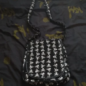 Pirat väska - Mycket fin väska som inte längre kommer till användning. Den har ett justerbart axelräm och den finns en innerficka med dragkedja. Själva väskan stängs med kardborrband. Frakt tillkommer 