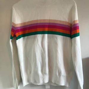 Tröja med polokrage och regnbågsmönster - Jättefin långärmad tröja med en hög krage från & other stories. Frakten betalas av köparen och ligger på ca 40 kr.