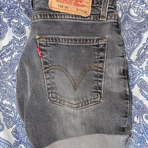 Levis 529 shorts W24 & L32 - Ett par gråa shorts i riktigt fint skick. Inga slitningar annat än ena sömnen på bakfickan. Storlek W24 & L32. Säljes pågrund av att de är för små. Frakt tillkommer.