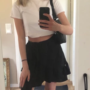 Svart omlott kjol med volanger  - Söt volangkjol som går omlott och knyts i midjan, trendig och är väldigt lätt att stylea upp även fast den är rätt så basic. Jag på bilderna är 167cm lång, men kjolen skulle både fungera på någon som är något längre/ kortare. Nypris: 330kr 