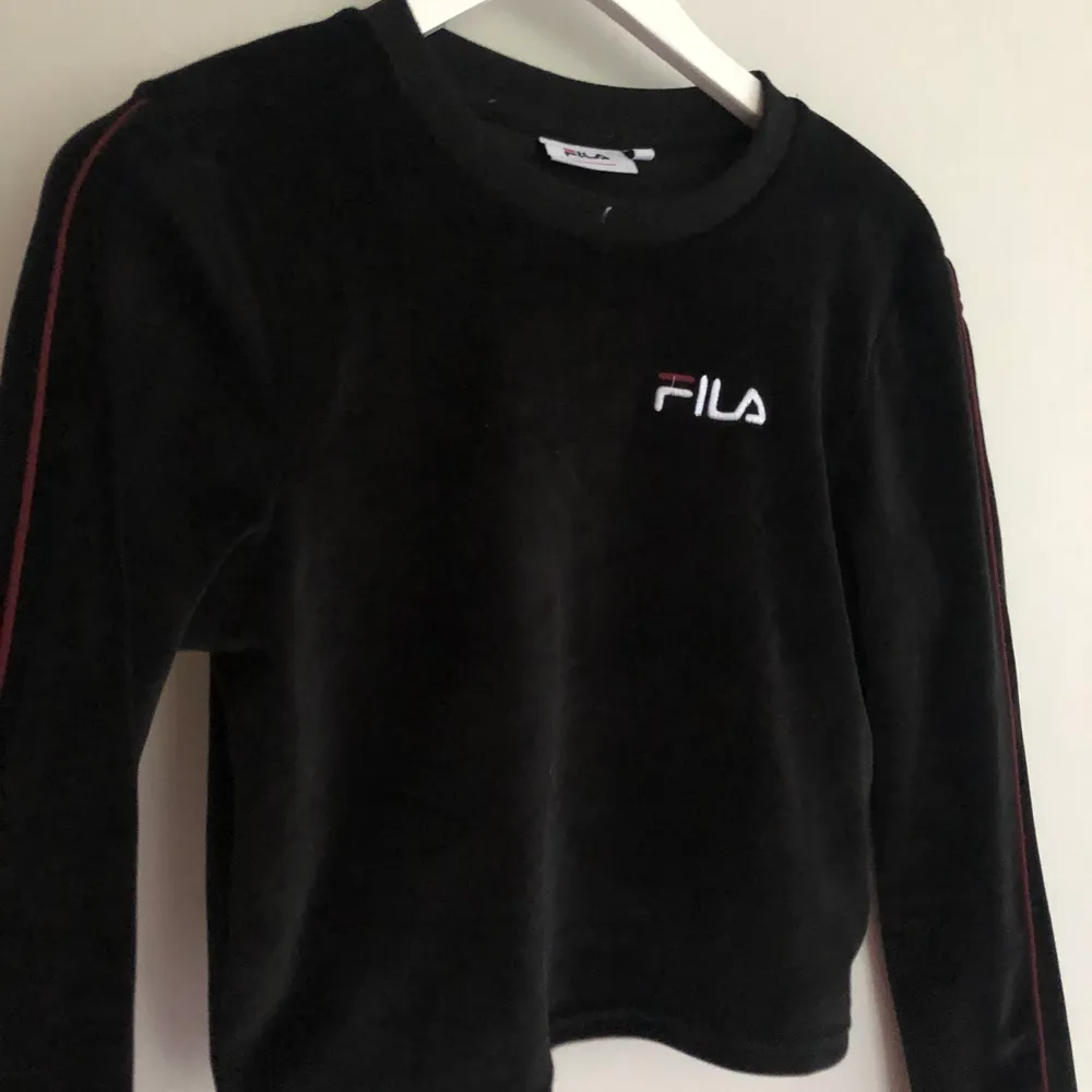 Supersnygg svart tröja från Fila! I mjukt material med en röd rand på ärmarna. Sitter tajt på mig som har S/M men kan passa XS också! Frakt tillkommer✨. Neuletakit & Villapaidat.