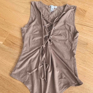  - Body från Nelly. Mocka material. Knytning framtill. Superfin är den! Passar även mig som har S med mindre byst. 