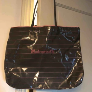  - Snygg väska i lite plast/regnklädes material me rosa räder o en text på mitten där d står mademoiselle på mitten, frakt 44 kronor 
