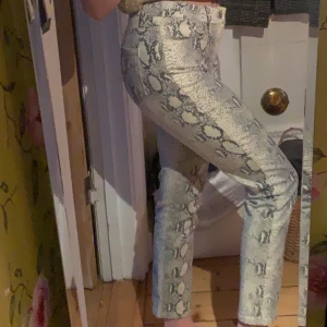 Byxor - Ormmönstrade jeans, storlek 34, mycket bra skick. Fakt ingår ej i priset!!
