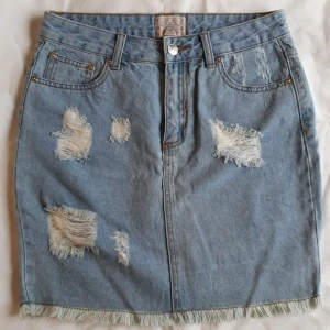 Ljus jeanskjol med slitningar  - Skitsnygg jeanskjol med slitningar. Använd en gång, blev sedan för liten och har legat gömd i garderoben. Perfekt skick. Köpt på Carlings för ca 5 år sedan. Fickor både fram och bak. Frakt inräknad i priset! 