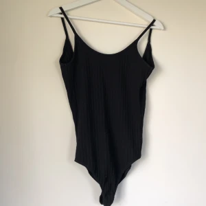 Snygg body med öppen rygg  - En jättesnygg svart enkel body med öppen rygg. Säljes pga använts inte längre.. frakt tillkommer 