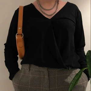 Omlottblus i ribbat satin - Jättesöt v-ringad omlottblus i ribbat satin❣️Använd fåtal gånger så den är i väldigt bra skick utan några slitningar/hål/fläckar. Passar allt från S-L då tyget är elastiskt.  Nypris 300kr, säljer för 69kr