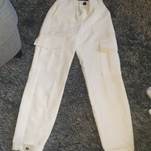 Vita cargopants - Grymt snygga cargopants från Bershka i storlek 32. Jag älskar själv dessa men de är för små för mig tyvärr. Använd enstaka gånger. 