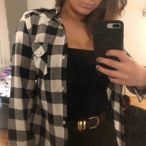  - Frakt ingår i pris! Skitsnygg oanvänd svart- och vitrutig skjorta. Skulle säga att den är ganska liten i storleken