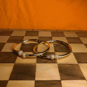  - Två jättefina guldiga armband! Kan även användas som gardinomtag. Frakt tillkommer.