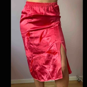  - Rosa kjol med broderade blommor🌸🌸  En snygg liten slits som framhäver🤩