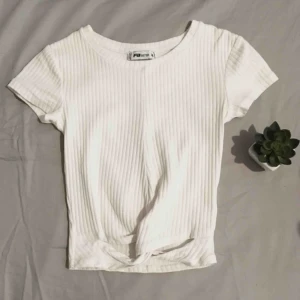  - Vit ribbad crop topp med ”virvel”/knyt/rosett/hål detalj längst ner i bra skick! 75kr + frakt!
