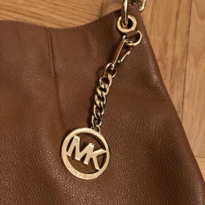  - Äkta Michael Kors brun axelremsväska som är i jätte bra skick, pris 900kr ✨