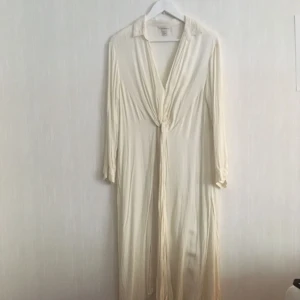  - Vacker lång skjorta i benvitt med djup v-ringning och knytbara detaljer på framsidan.  Kan upphämtas i Göteborg eller skickas. Köparen står för frakten! 