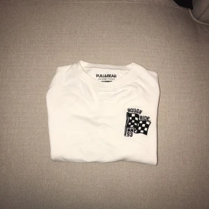  - Vit tröja med svart detalj. 