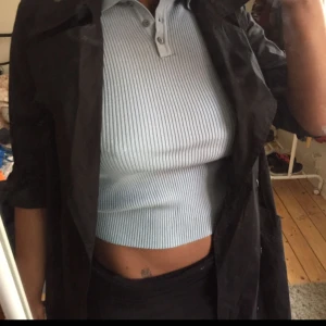  - En lång svart kappa med många knappar passar för våren, tjock tyg.