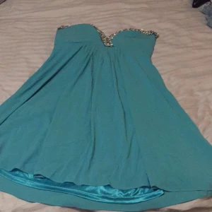 - Superfin turkos klänning med fina detaljer och avtagbara axelband. Samt att man kan knyta i midjan. Aldrig använd med lapparna kvar.  

Jag kan frakta eller mötas upp. Vid frakt står köparen för porto. 
Pris kan diskuteras vid snabb affär.

