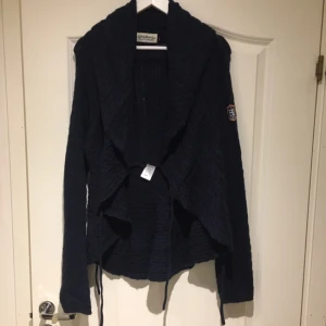  - En marinblå kofta från Hamton & republic i strl 40/42. Knytning på sidorna som ger ett fint fall bak och sidorna av koftan.