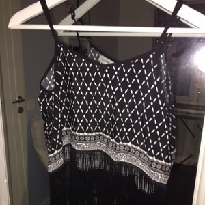  - Svart och vit mönstrat linne med svarta fransar längst ner, kommer från H&Ms coachella collection som är limited edition, storleken är 36/S, Vid frakt tillkommer 20 kr