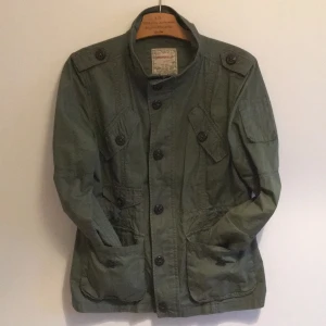  - Militärgrön vårjacka. Någon knapp behöver lite kärlek men i övrigt i mycket gott skick. Köparen står för frakten. 