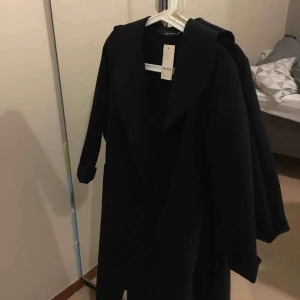  - En helt oanvänd kappa! Tjock i tyg! Tyget påminner om mocka  Jätte fin och elegant!  