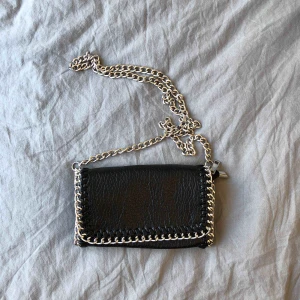  - Äkta TIAMO väska med avtagbara axelband. Köpt för 450kr och endast använd ett par gånger! iPhone 8 Plus får plats.  Pris: 199kr+frakt