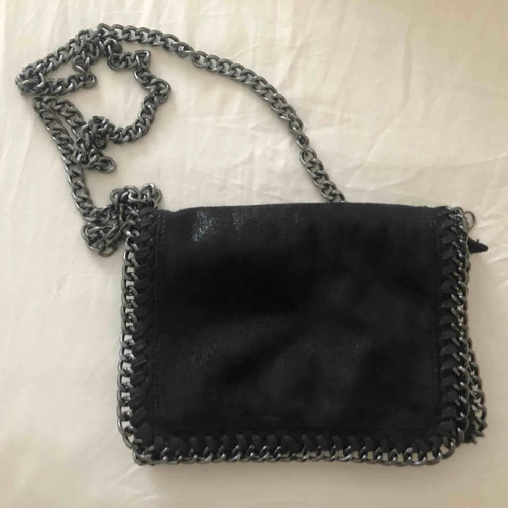 En svart handväska i mockaillusion med glitter. Frakt tillkommer. . Väskor.