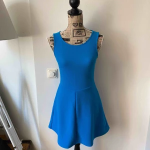  - Fin blå klänning köpt i Spanien och aldrig använd. Snygg öppen rygg.