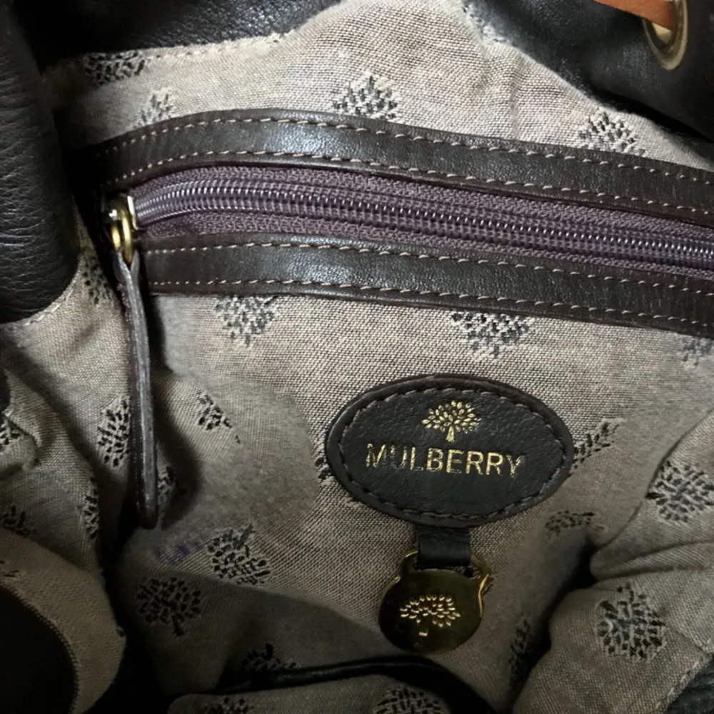 En aldrig använt Mulberry väska (kopia) i äkta läder. Mörkbrun med ljusbruna/guldiga detaljer. Rymmer mycket och är en perfekt everyday väska. . Väskor.