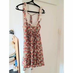  - Superfin blommig klänning med snygga detaljer. Inköpt second hand. Väldigt bra skick. Skickas mot portokostnad.