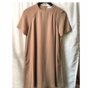  - Oanvänd klänning i ”klockmodell” 