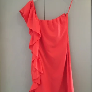  - Asymmetrisk kort klänning m dragkedja i sidan. Härlig korall färg. 